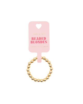 Gold beaded ring on a pink card with 'Beaded Blondes' text against a white background