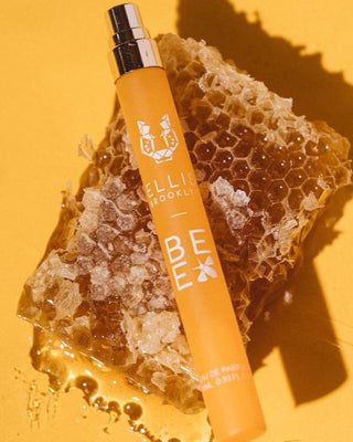 Orange bottle labeled 'BEX' on a honeycomb against a yellow background