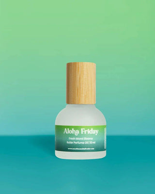 Bottle of Aloha Friday roller perfume oil with a wooden cap on a gradient green and blue background