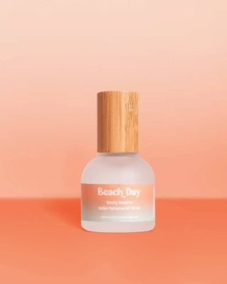 Perfume bottle labeled 'Beach Day' on a peach background