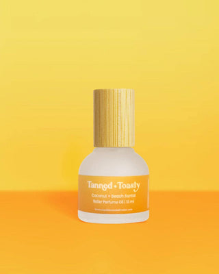 Perfume bottle labeled 'Tanned & Toasty' on a yellow and orange gradient background