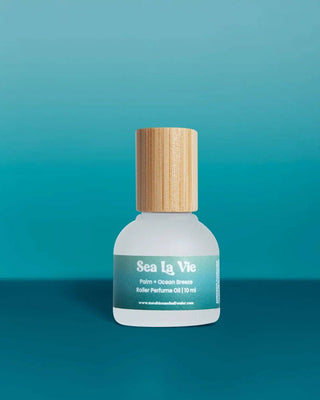 Sea La Vie perfume bottle with wooden cap on a teal background