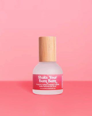 Perfume bottle labeled 'Shake Your Bum Bum' on a pink background