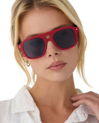 Woman wearing red sunglasses with a white background