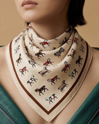Person wearing a patterned scarf with a neutral background