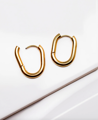Gold hoop earrings on a white surface