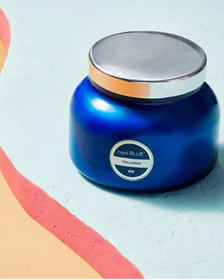 Blue candle with a silver lid on a light background