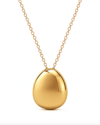 Gold necklace with a round pendant on a white background