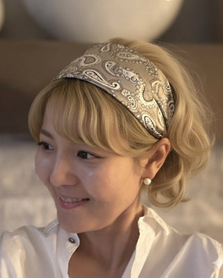 Woman wearing a patterned headband with a blurred background