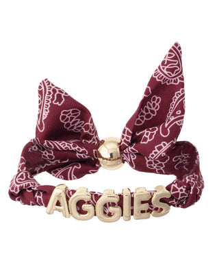 Maroon bandana slider bracelet with gold 'AGGIES' letters on a white background