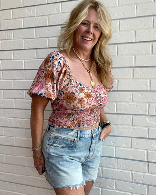 Women's floral sweetheart crop top with a square neckline, flowy sleeves, smocked back, and multicolor floral print.
