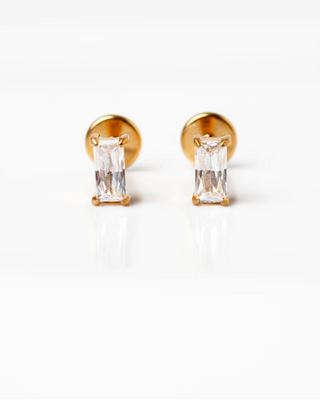 Gold earrings with clear gemstones on a white background