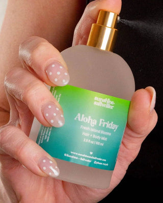 Hand holding a bottle of 'Aloha Friday' product with a green label.