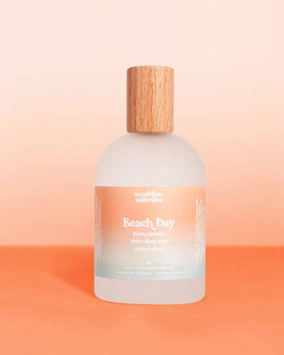 Bottle of 'Beach Day' body wash with a wooden cap on a peach background