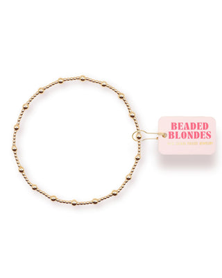 Gold beaded anklet with 'Beaded Blondes' packaging on a white background