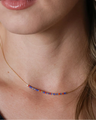 Necklace with colorful beads that spells 'best friend' in morse code worn by a woman.