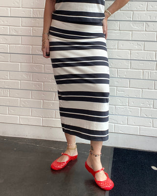 Women's black and cream striped cotton jersey midi skirt with a fitted silhouette, elastic waistband, and center back slit.