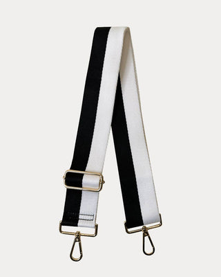 Black and white striped bag strap with gold hardware on a light gray background