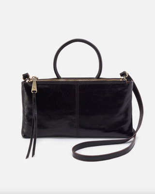 Black leather handbag with a strap on a white background