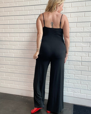 Women's black wide leg jersey jumpsuit with adjustable spaghetti straps, V-neckline, and a relaxed full-length silhouette.