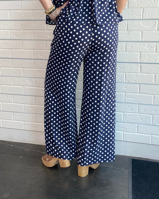 Women's navy and white polka dot wide-leg trousers with a smocked waistband, pull-on fit, front pockets, and a relaxed drapey silhouette back picture
