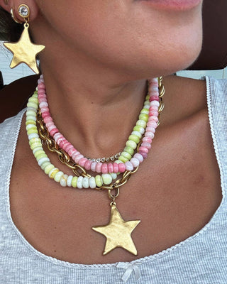 Close-up of a person wearing a colorful beaded necklace with star pendants.
