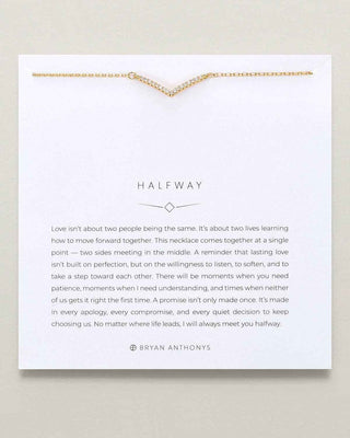 A gold necklace displayed on a white card with printed message art. The necklace has a V-shaped design with small chain links forming a continuous line across the top.