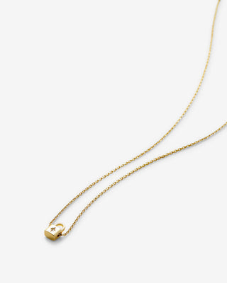 Gold necklace with a small lock pendant on a white background