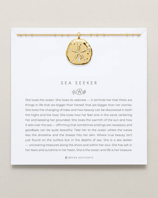 Gold necklace with sand dollar pendant on a card with text