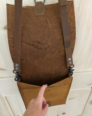 Brown leather bag with straps on a white background
