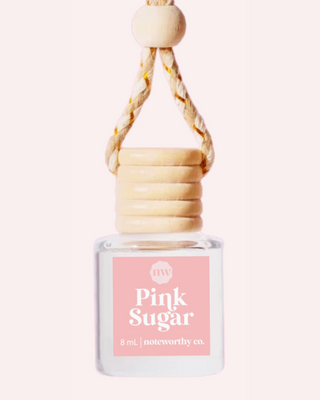 Small bottle car diffuser labeled 'Pink Sugar' with a wooden handle on a white background