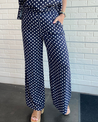 Women's navy and white polka dot wide-leg trousers with a smocked waistband, pull-on fit, front pockets, and a relaxed drapey silhouette front picture