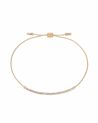 Gold bracelet with small stones  that spell out 'cherished' in morse code on a white background