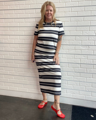Women's black and cream striped cotton jersey midi skirt with a fitted silhouette, elastic waistband, and center back slit.
