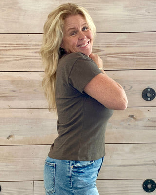 Woman posing against a wooden wall