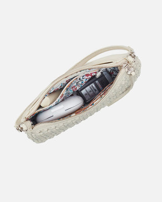 Beige pouch with floral interior containing a phone and other items on a white background