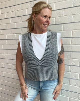 white tee with grey sweater vest over it