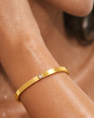 Ellie Vail Marjorie solitaire bangle bracelet featuring a cubic zirconia accent and water-resistant stainless steel.