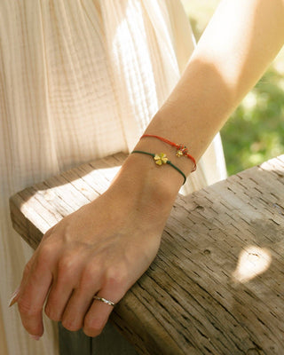 Close-up of a person's wrist with bracelets on a wooden surface