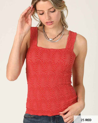 Woman wearing a red patterned tank top on a white background