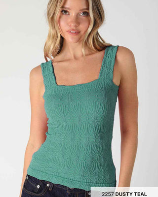 Woman wearing a green tank top on a white background