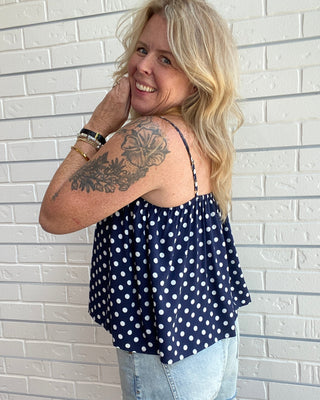 Women's navy and white polka dot tank top with spaghetti straps, an open neckline, and a relaxed fit side picture
