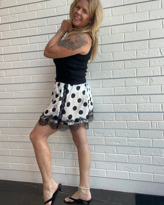 Polka Dot Lace Skirt at Ellipsis Boutique. A flowy satin skirt with a polka dot pattern, stretchy waist, and lace trim.
