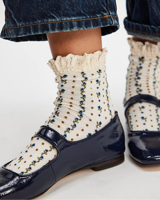 Navy shoes with white polka dot socks on a light background