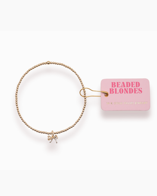 Gold beaded bracelet with pink packaging labeled 'Beaded Blondes' on a white background