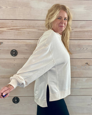 Woman wearing a white blouse against a wooden background