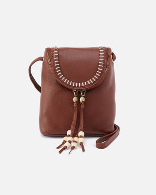 Brown leather crossbody bag with decorative tassels on a white background