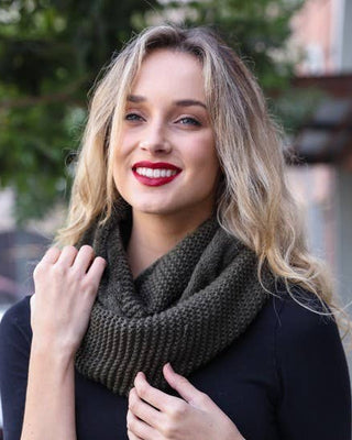 Woman wearing a dark green knitted scarf outdoors