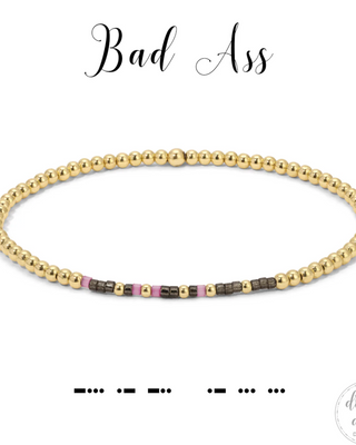 Gold beaded bracelet with colored accents on a white background, featuring the brand 'dot & dash design'.