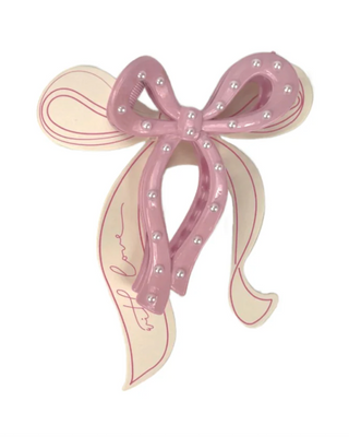 Decorative bow hair clip with pearls on a white background
